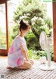 A woman sitting on the floor next to a fan.