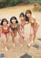 A group of young women in bikinis posing for a picture.