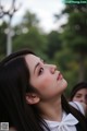 A woman with long black hair and a white shirt.