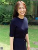 A woman in a blue dress smiles at the camera.