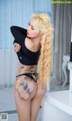 A woman with long blonde hair and tattoos on her body.